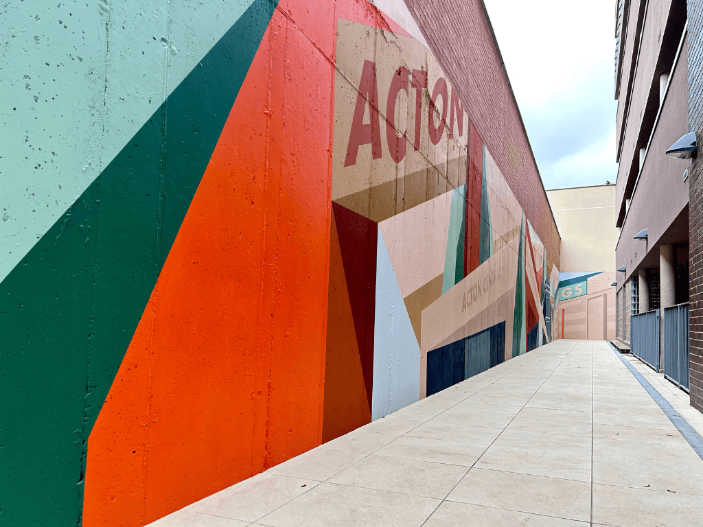 Colorful mural on a wall with the word 'ACTON' in an urban setting